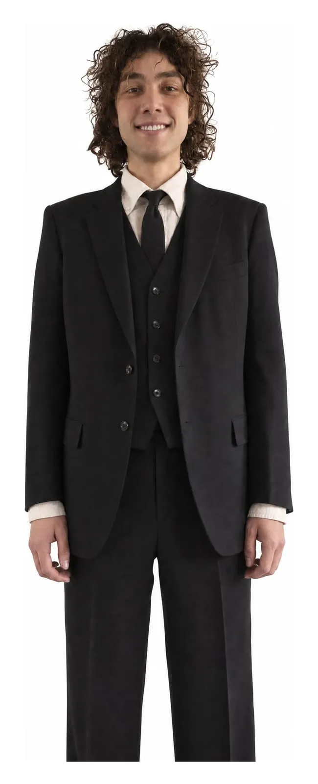 Luca McDonnell, standing, in a black three-piece suit against a white ground